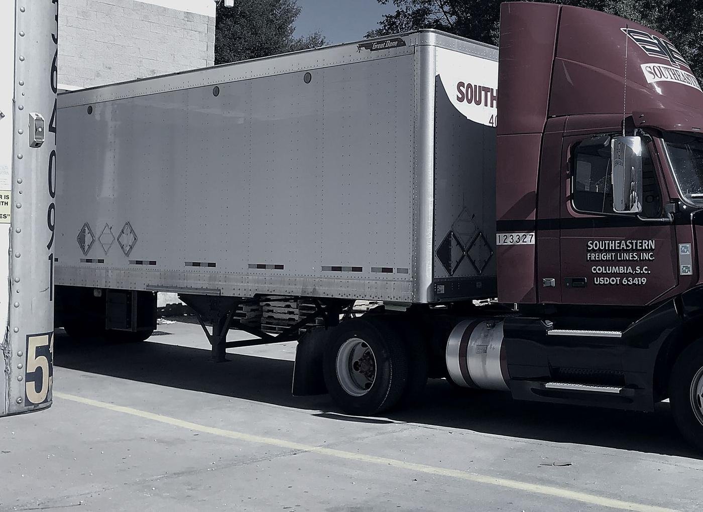 A tractor and dry van trailer positioned at a loading dock, ready to be worked.